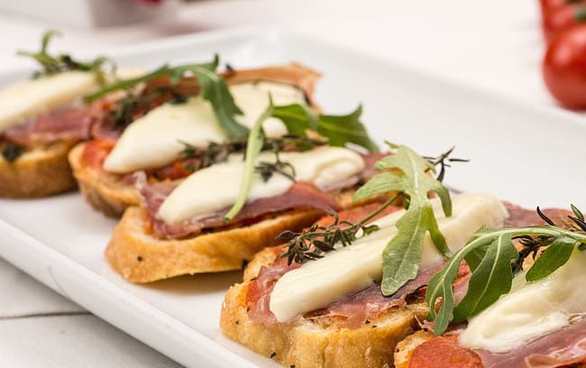 Canapés de camembert, tomate y bacon