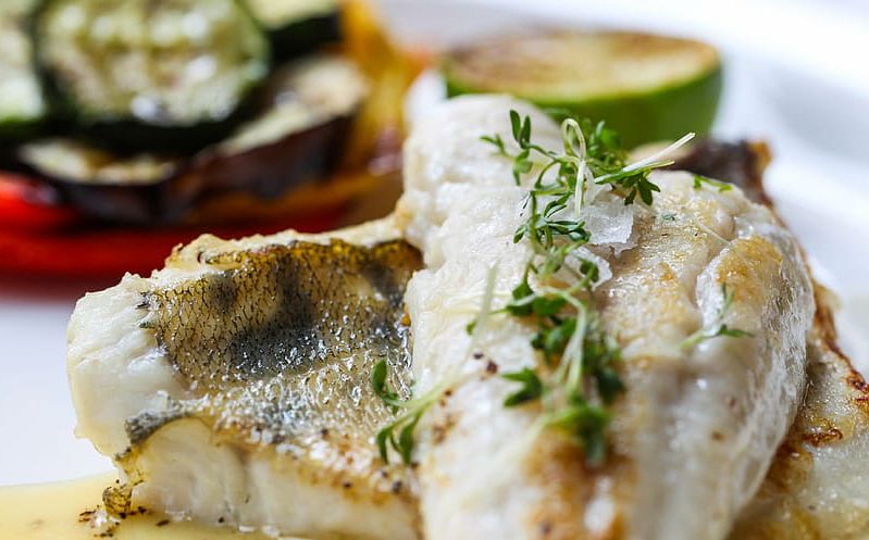 Lubina al horno con mantequilla y verduras salteadas