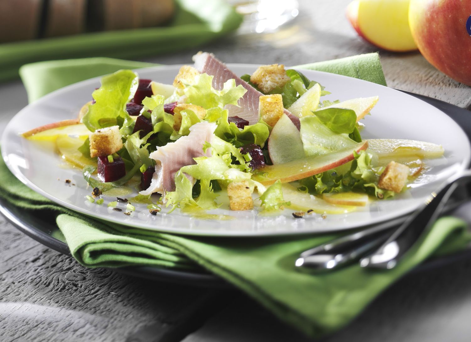 Ensalada de manzanas, remolacha, trucha ahumada y picatostes con bayas de enebro