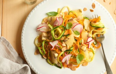 Espaguetis de calabacín y zanahoria con kiwis, rabanitos y almendras al aroma de limón