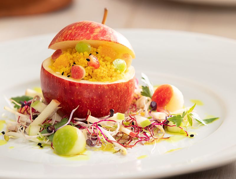 Manzana rellena de cuscús especiado y ensalada de brotes