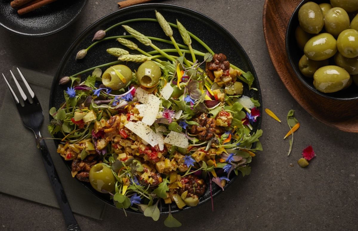 Ensalada de rúcula especiada con nueces, aceitunas y queso manchego